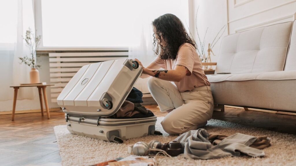 留学の持ち物をスーツケースに詰めている女の人。